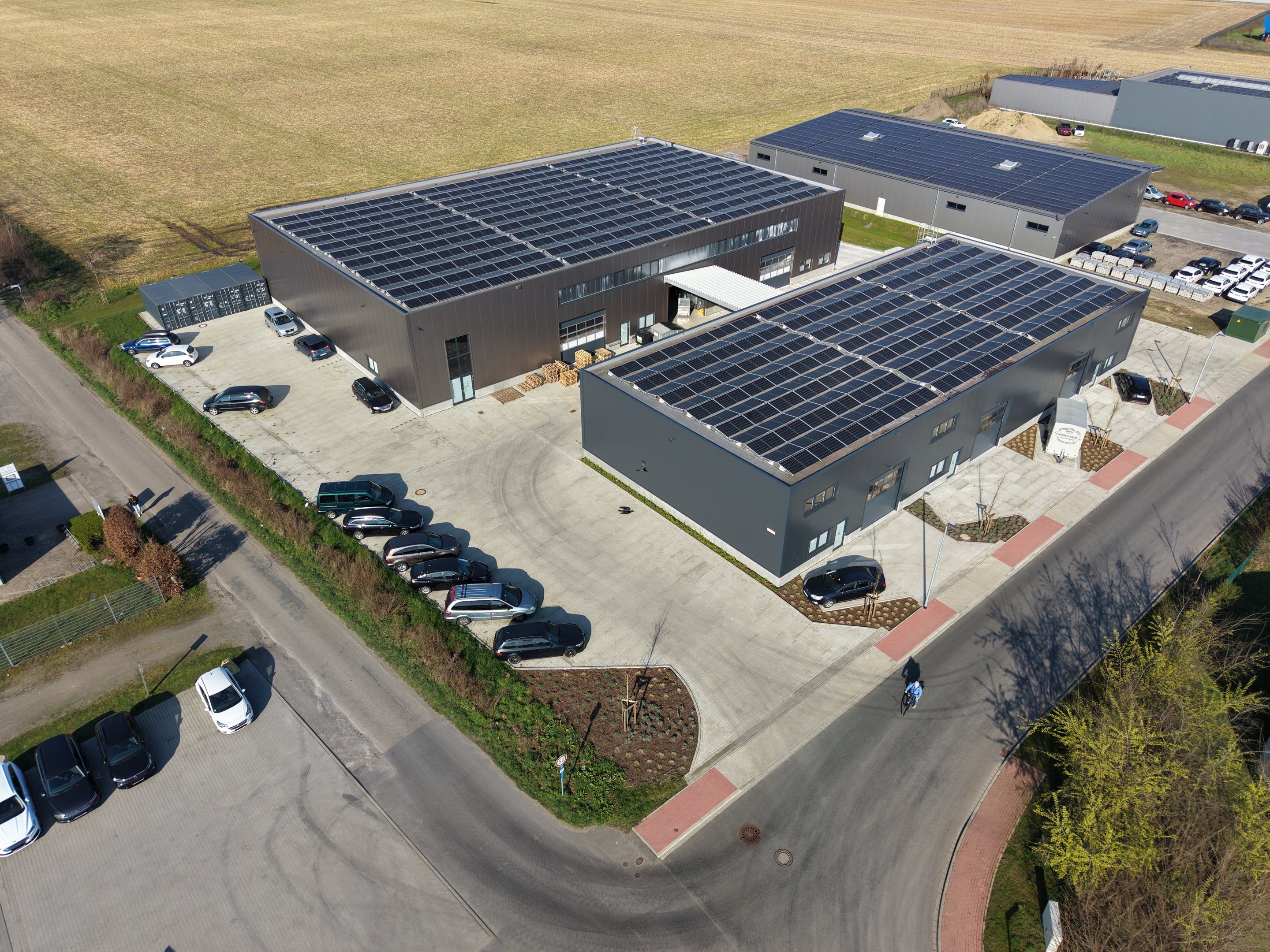 Luftbild des Business Parks Schwanenschlatt mit zwei neuen anthrazitfarbenen Hallen
